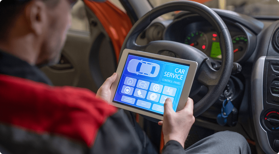 Auto mechanic using an app on a tablet to get help for car repairs