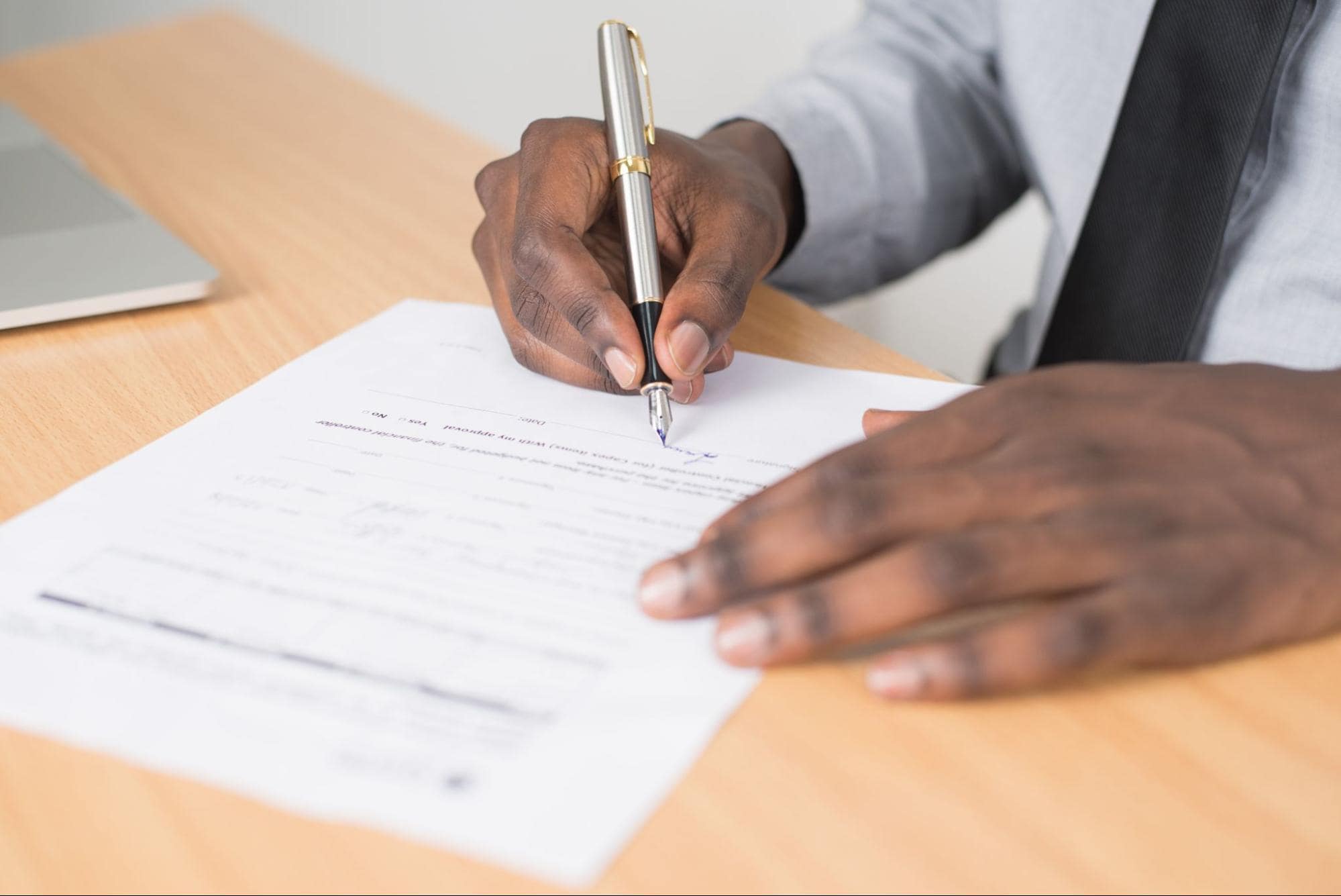 Close-up of hands adding signature on a document